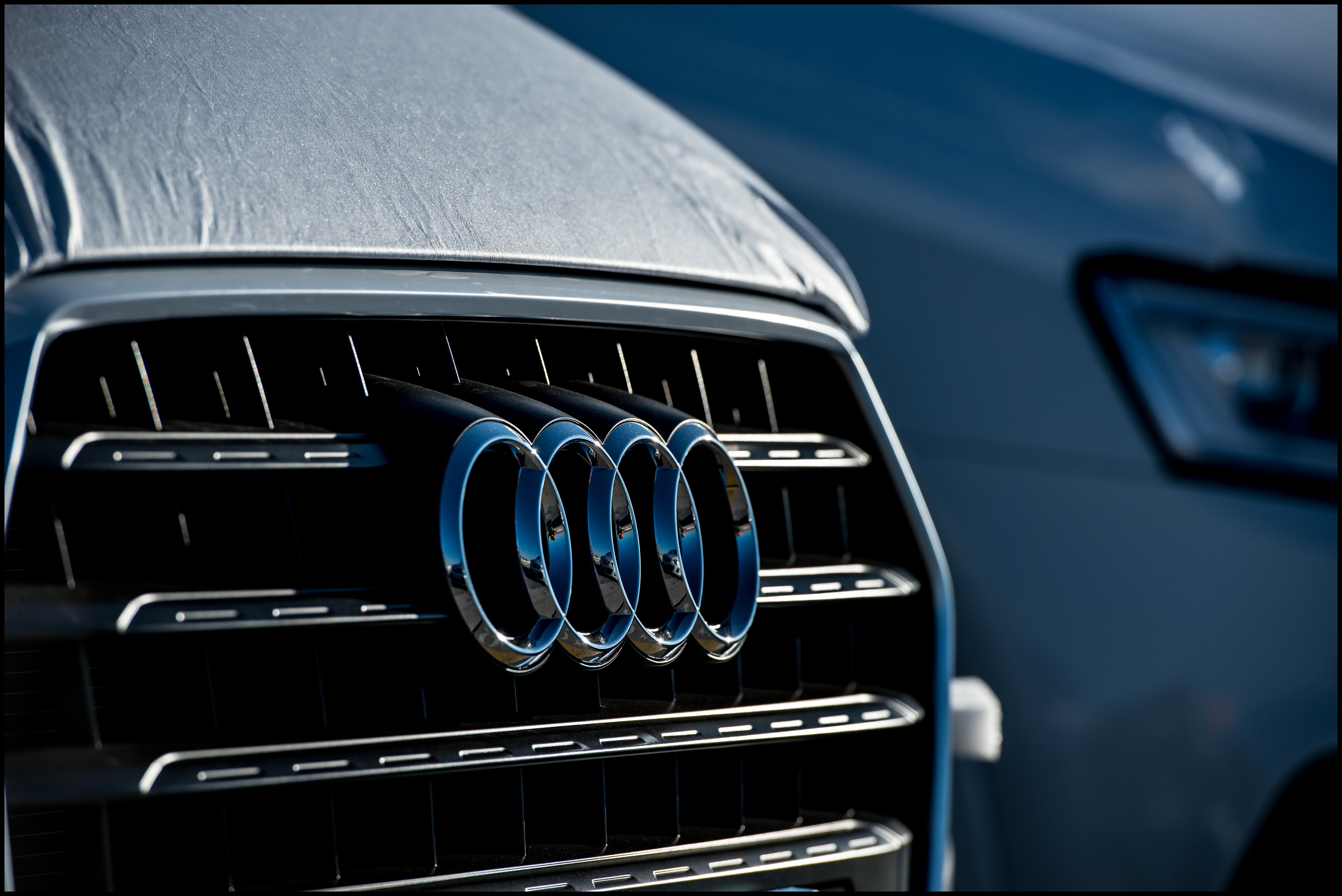 A close up view of the Audi emblem is seen on a new Audi vehicle